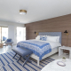 A white bed with blue and white comforter and sheets at Holiday House Palm Springs