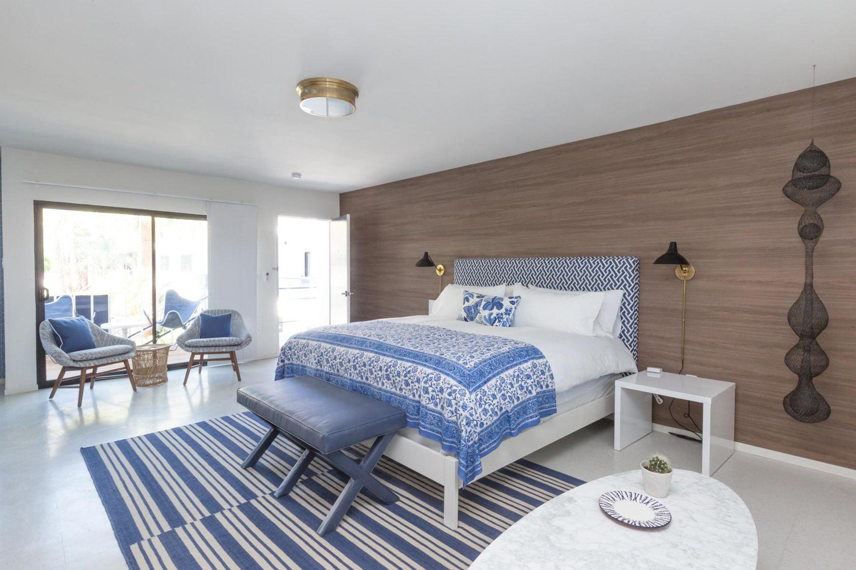 A white bed with blue and white comforter and sheets at Holiday House Palm Springs