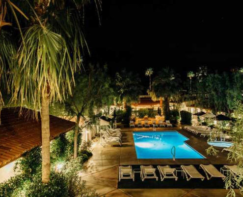 Alcazar Palm Springs’ outdoor pool, patio, and terrace at night