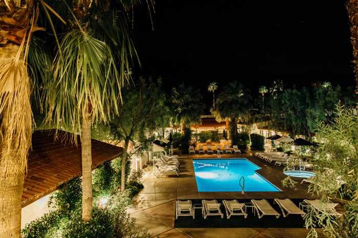 Alcazar Palm Springs’ outdoor pool, patio, and terrace at night