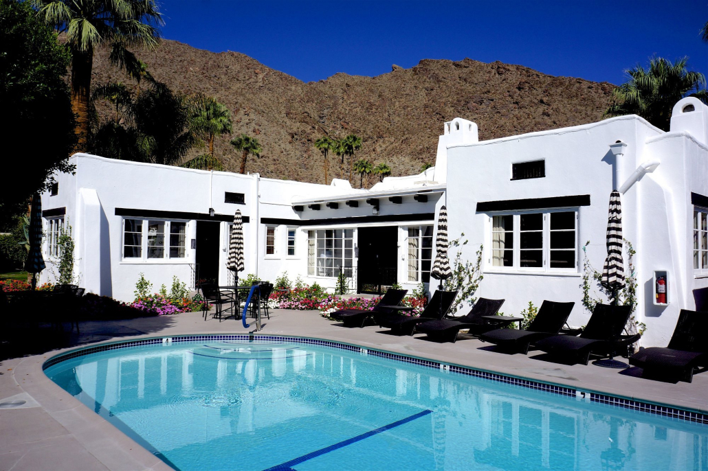 The pool at Amin Casa in front of a white bungalow with the San Jacinto Mountains in the background