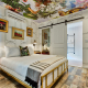 The La Reve Room at Dive Palm Springs with a floral design on the ceiling and hardwood floors and a white bed