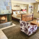 A room at the Old Ranch Inn with a fireplace and cow-print chair and king-sized bed