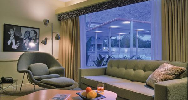 A mid-century modern couch in front of a large window in the Rat Pack room at Orbit In Palm Springs