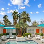 Puffy white clouds fill the blue sky above the courtyard pool at The Weekend Palm Springs