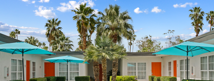 Puffy white clouds fill the blue sky above the courtyard pool at The Weekend Palm Springs