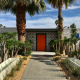 Orange door and white brick entrance to The Weekend Palm Springs mid-century modern hotel in Palm Springs, California