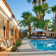 The swimming pool at Dive Palm Springs with swings next to it and palm trees behind it