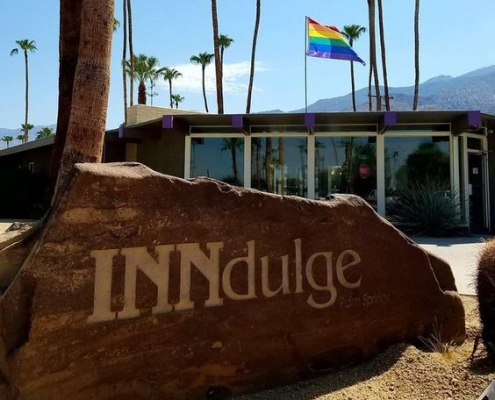 A rock sign that says INNdulge in front of INNdulge Palm Springs gay men's clothing-optional resort in Palm Springs, California