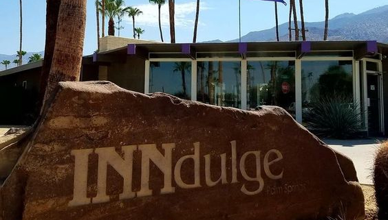 A rock sign that says INNdulge in front of INNdulge Palm Springs gay men's clothing-optional resort in Palm Springs, California