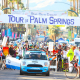 A sign reading "Tour de Palm Springs" with a car and people underneath it