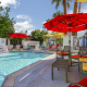 Red umbrellas provide shade next to the pool at the Inn at Palm Springs in Palm Springs, California
