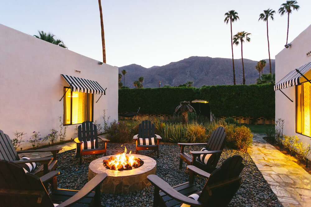 Black Adirondack chairs surround the blazing fire pit during an evening at Hotel El Cid in Palm Springs