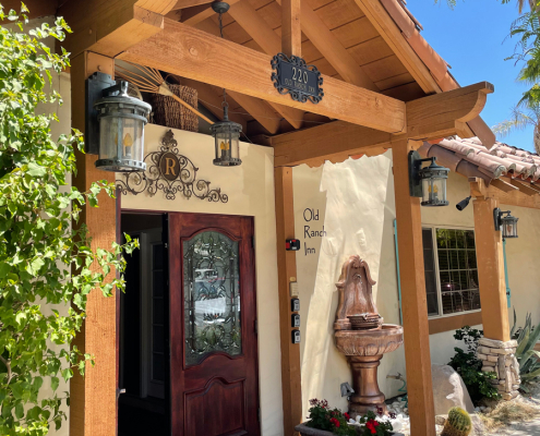 The front entrance to Old Ranch Inn in Palm Springs has a fountain and wood beams