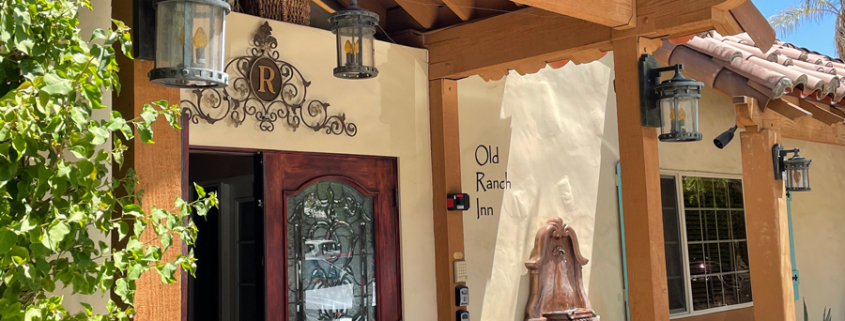 The front entrance to Old Ranch Inn in Palm Springs has a fountain and wood beams