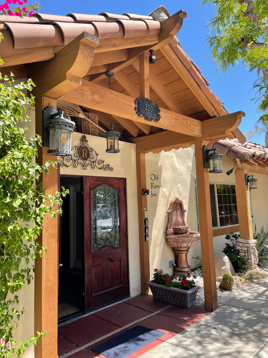 The front entrance to Old Ranch Inn in Palm Springs has a fountain and wood beams