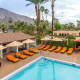 Orange lounge chairs surround the pool at Little Paradise Hotel in Palm Springs, California