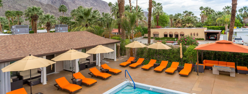 Orange lounge chairs surround the pool at Little Paradise Hotel in Palm Springs, California