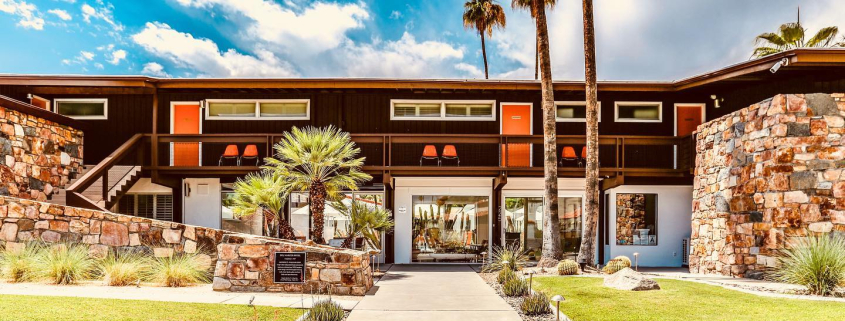 The stone front of Del Marcos Hotel with orange doors