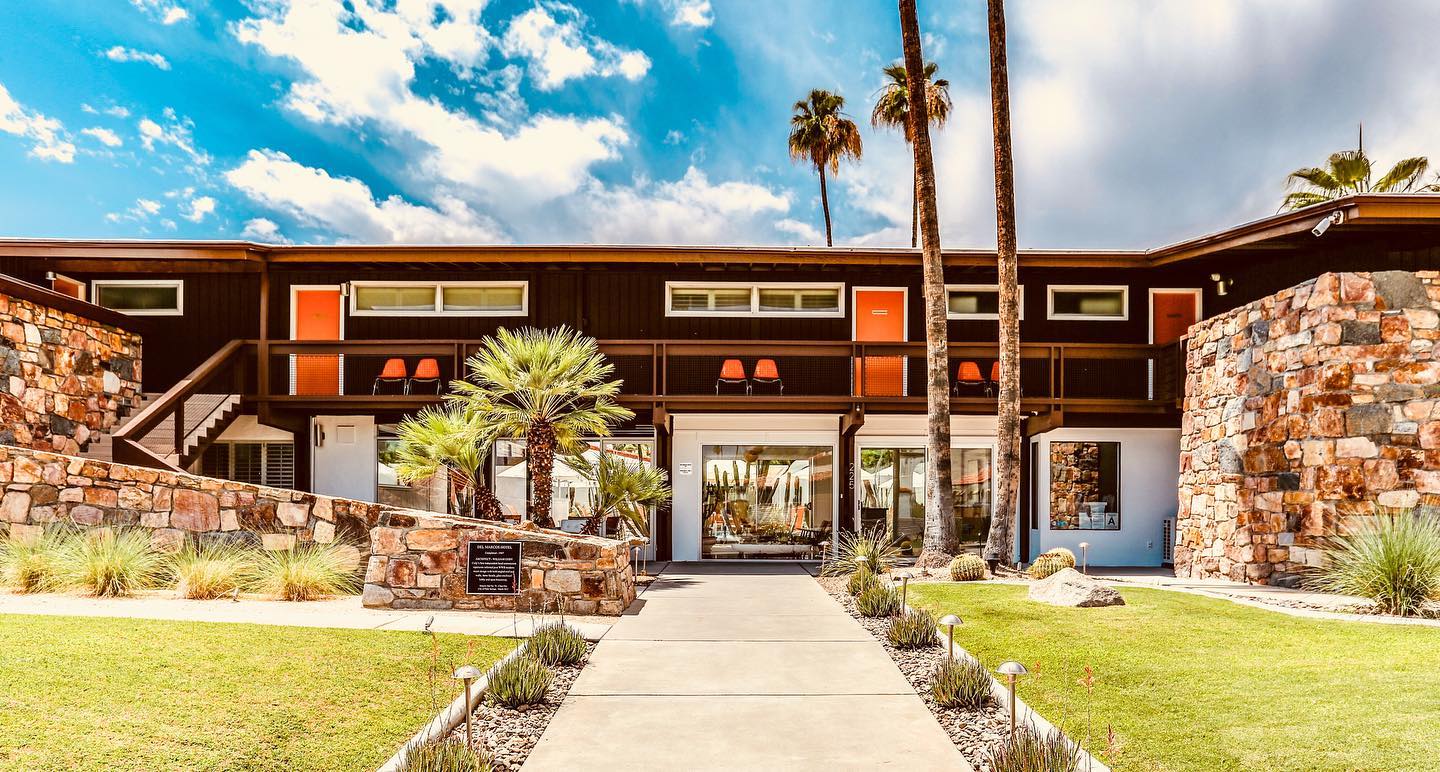 The stone front of Del Marcos Hotel with orange doors