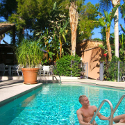 Two white men at the pool at Triangle Inn Palm Springs, a men's clothing-optional boutique hotel in Palm Springs, California