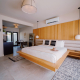 A large king bed with a white comforter is in the center of a room at Azure Sky Hotel in Palm Springs, California