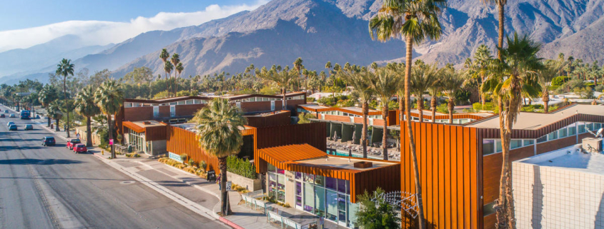 An aerial view of the mid-century architecture of Arrive Palm Springs with the San Jacinto Mountains in the background