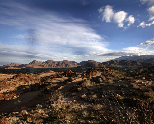 A desert landscape with blue skies and puffy clouds