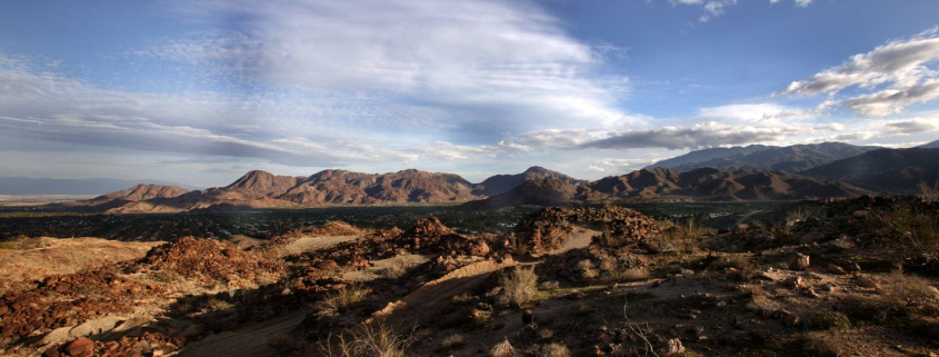 A desert landscape with blue skies and puffy clouds