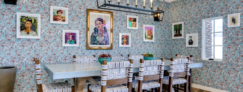 Art hangs on a brightly wallpapered wall at Azucar restaurant inside La Serena Villas