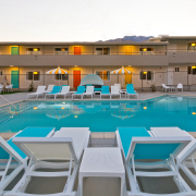 The pool at The Cole Hotel surrounded by blue and white chaise loungers