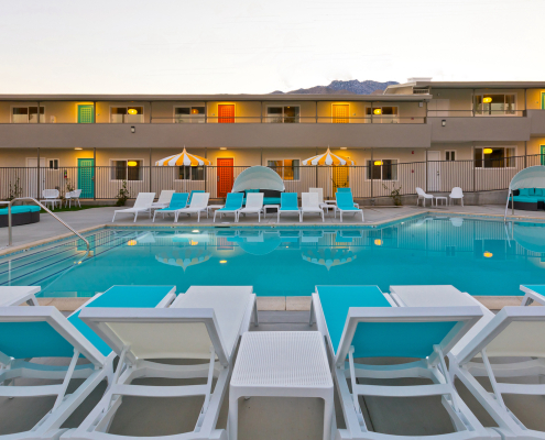 The pool at The Cole Hotel surrounded by blue and white chaise loungers