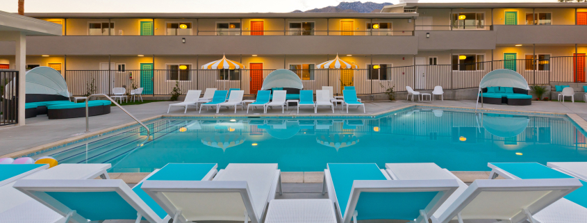 The pool at The Cole Hotel surrounded by blue and white chaise loungers