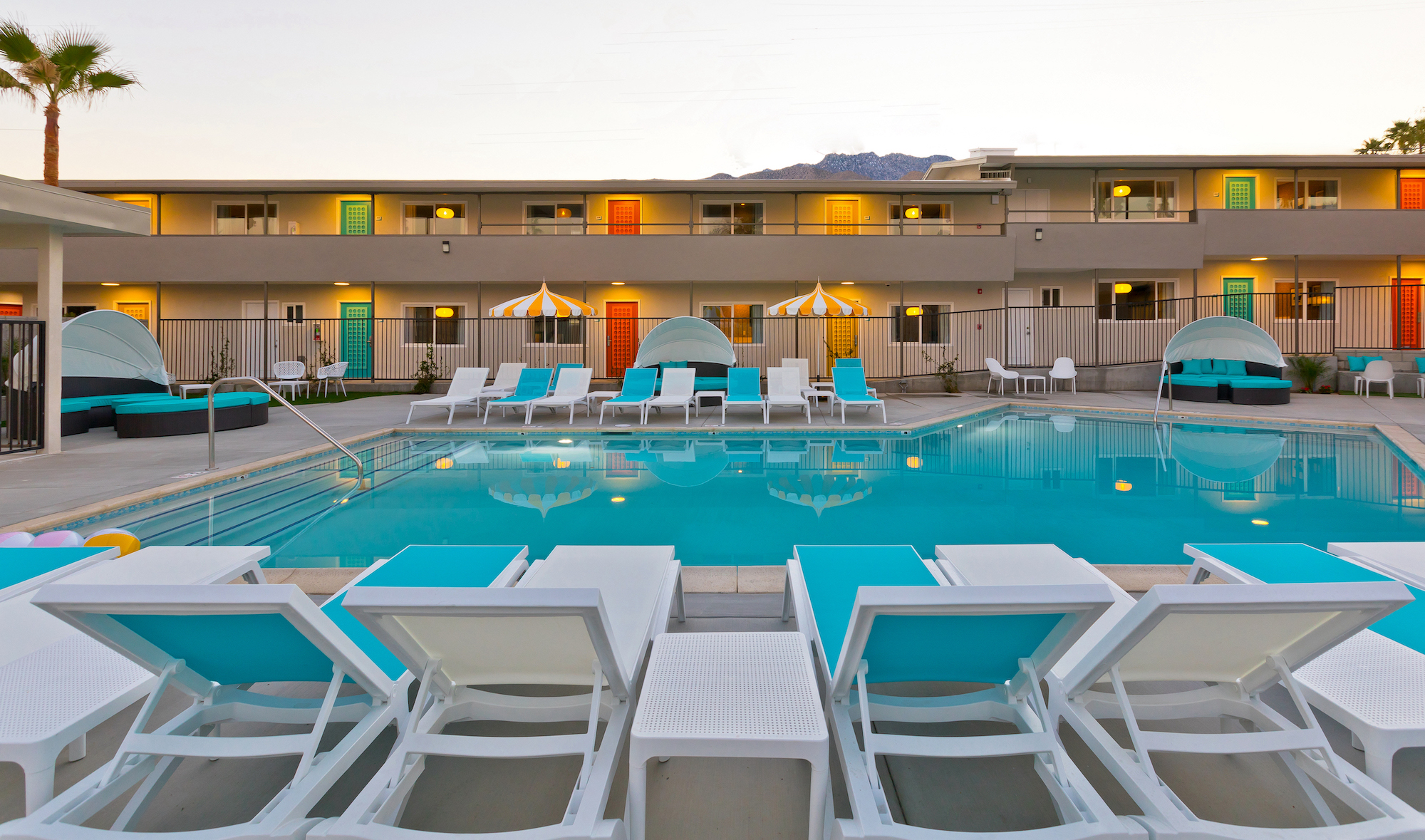 The pool at The Cole Hotel surrounded by blue and white chaise loungers