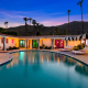 The pool at the Spirit of Sofia hotel in Palm Springs, California, in the evening with colored lights on in the room windows
