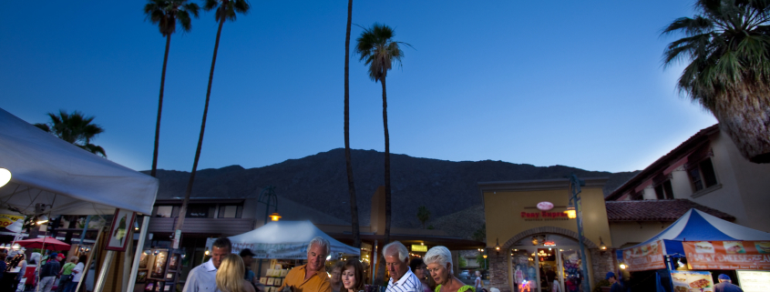 People look at items for sale as night falls over the Village Fest street fair in Palm Springs