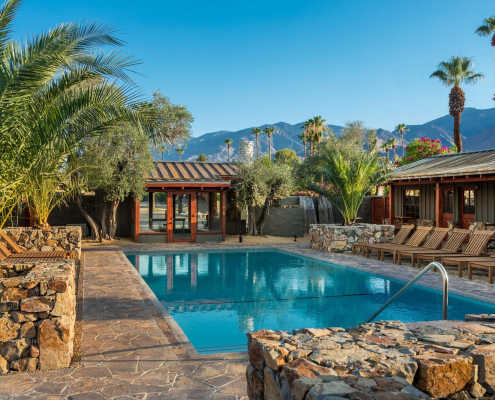 Rocky ledges and palms surround the beautiful pool at Sparrows Lodge Hotel in Palm Springs, California