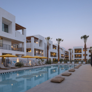 The pool at Drift Palm Springs surrounded by palm trees and loungers and yellow umbrellas