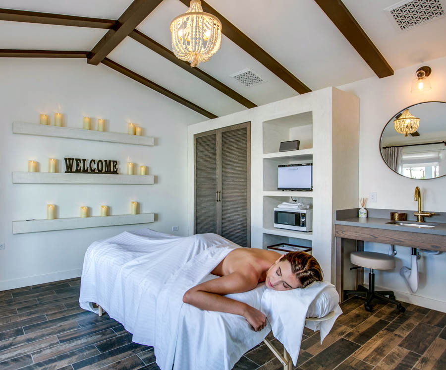 A woman on a table covered by a white blanket prepares to have a massage at Whisper's Spa at La Serena Villas in Palm Springs, California