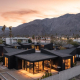 An aerial view of the four black buildings that make up Blackhaus with the San Jacinto Mountains in the background