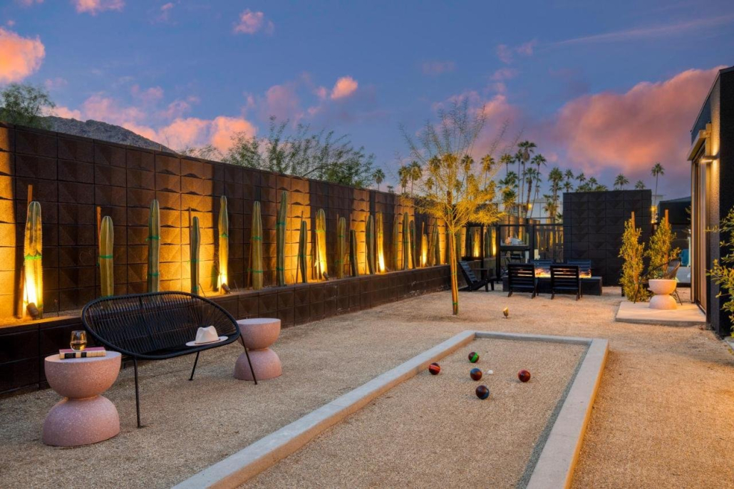 A bocce ball court at Blackhaus in Palm Springs, California, with pink clouds and palm trees in the background