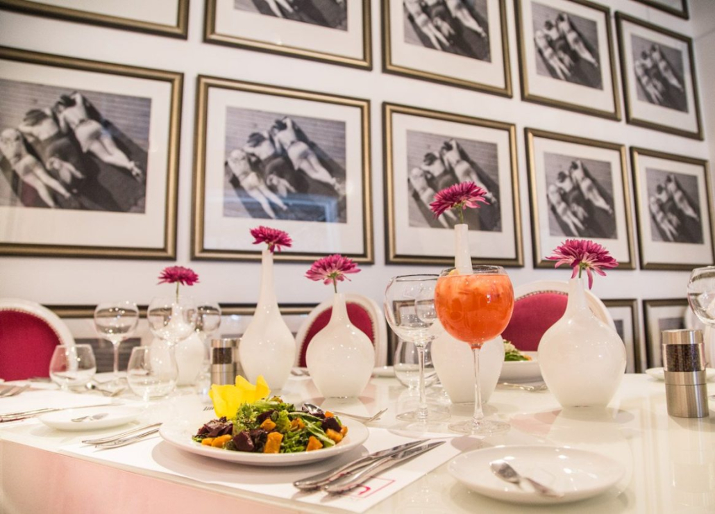 A plate of food and a cocktail on a white table