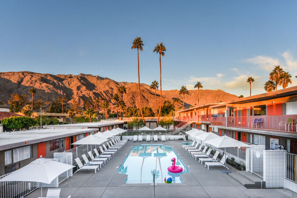 A pink flamingo float in the pool at Skylark Hotel Palm Springs with the mountains in the background