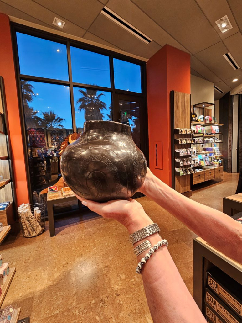A woman holds a piece of pottery inside the gift shop at the Agua Caliente Cultural Museum