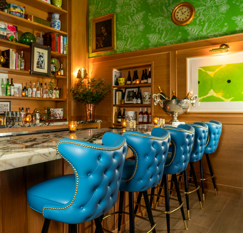 Blue leather chairs lined up in front of the bar at Bar Cecil in Palm Springs, California