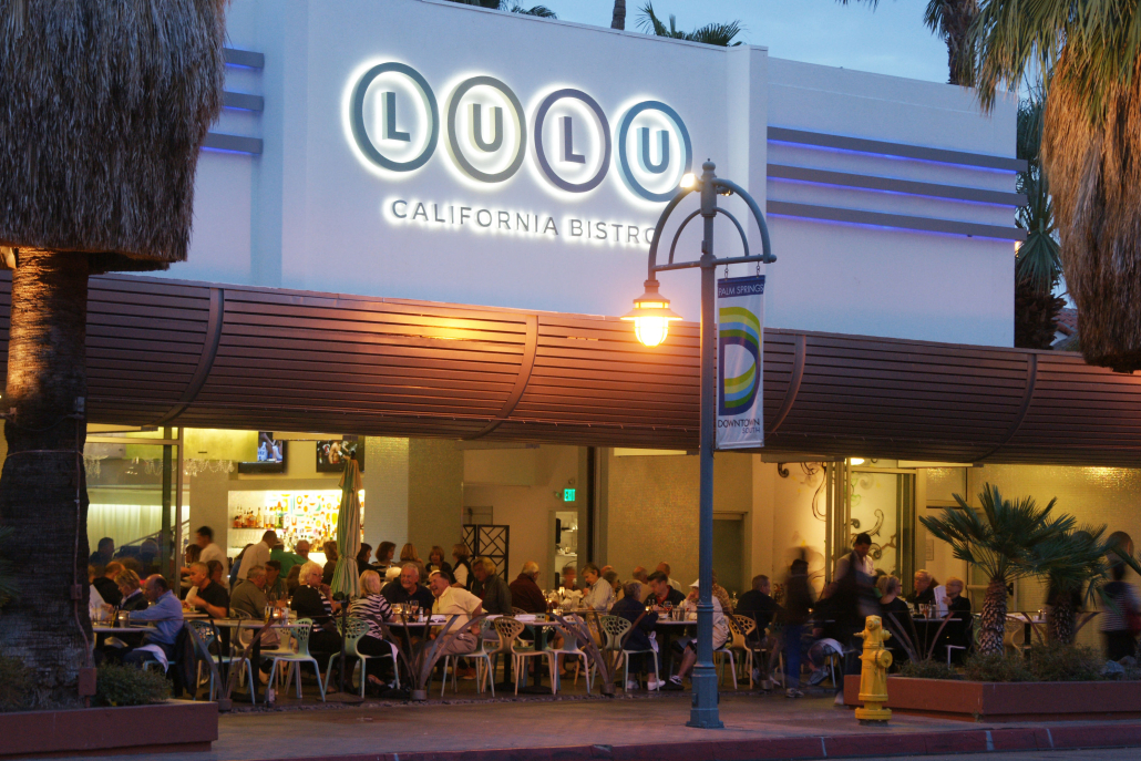 Diners sit at tables outside of Lulu California Bistro in Palm Springs, California