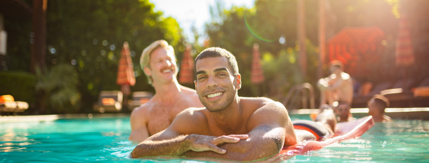 A Black man and a white blonde man in the pool at Santiago Resort in Palm Springs, California