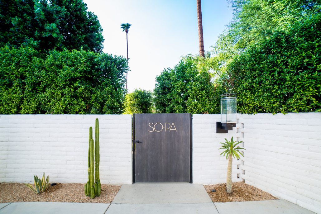 A white wall with a gate that reads "So•Pa"