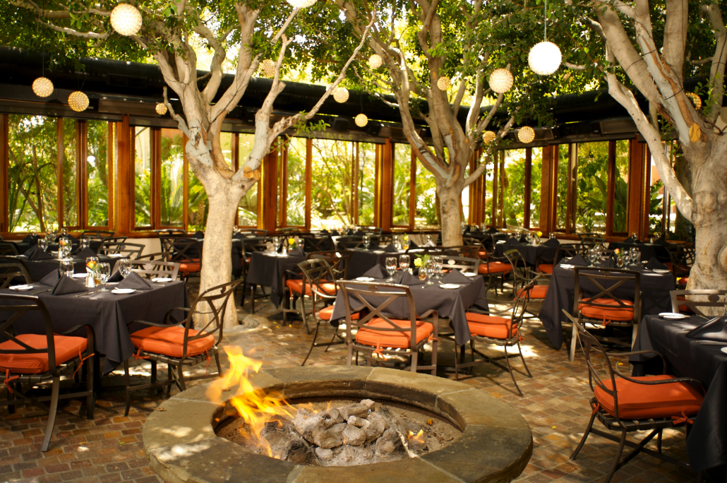 Empty tables and a fire pit on the outdoor patio at Spencer's in Palm Springs, California