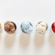 Five bowls of colorful ice cream lined up in white bowls